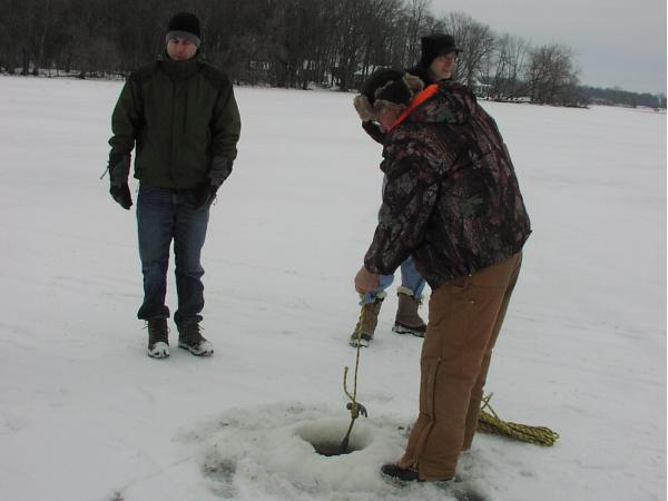 Larry Steeves is measuring the depth to the sediment.  Bill Arnold (left) and John Gulliver (right) are watching